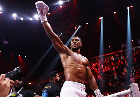 Boxer and Touch Tuina client Anthony Joshua punches the air after winning his title fight in Saudi Arabia